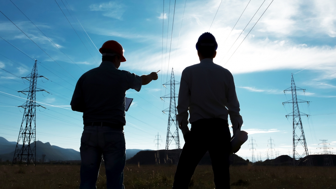 electrical workers surveying power lines