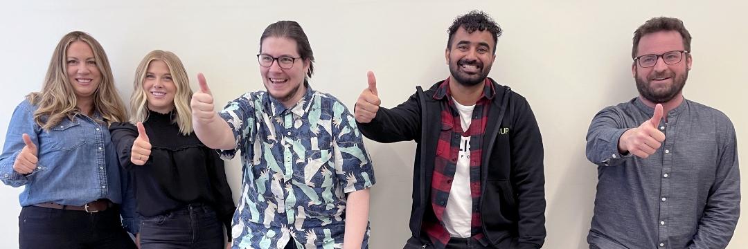 Upanup employees smiling with thumbs up